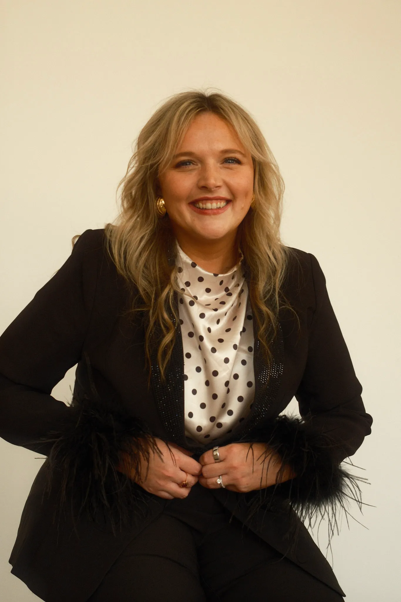 Grace Lakey smiling in a black blazer with a polka-dot top